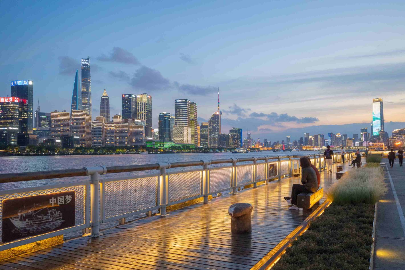 Family walking along the Bund with Pudong skyline in Shanghai, China